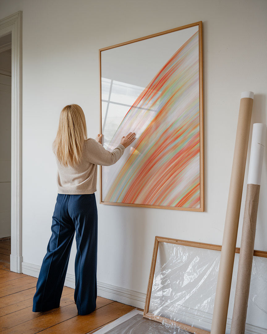 Modern abstract poster featuring deep orange and green tones, styled in a contemporary interior.